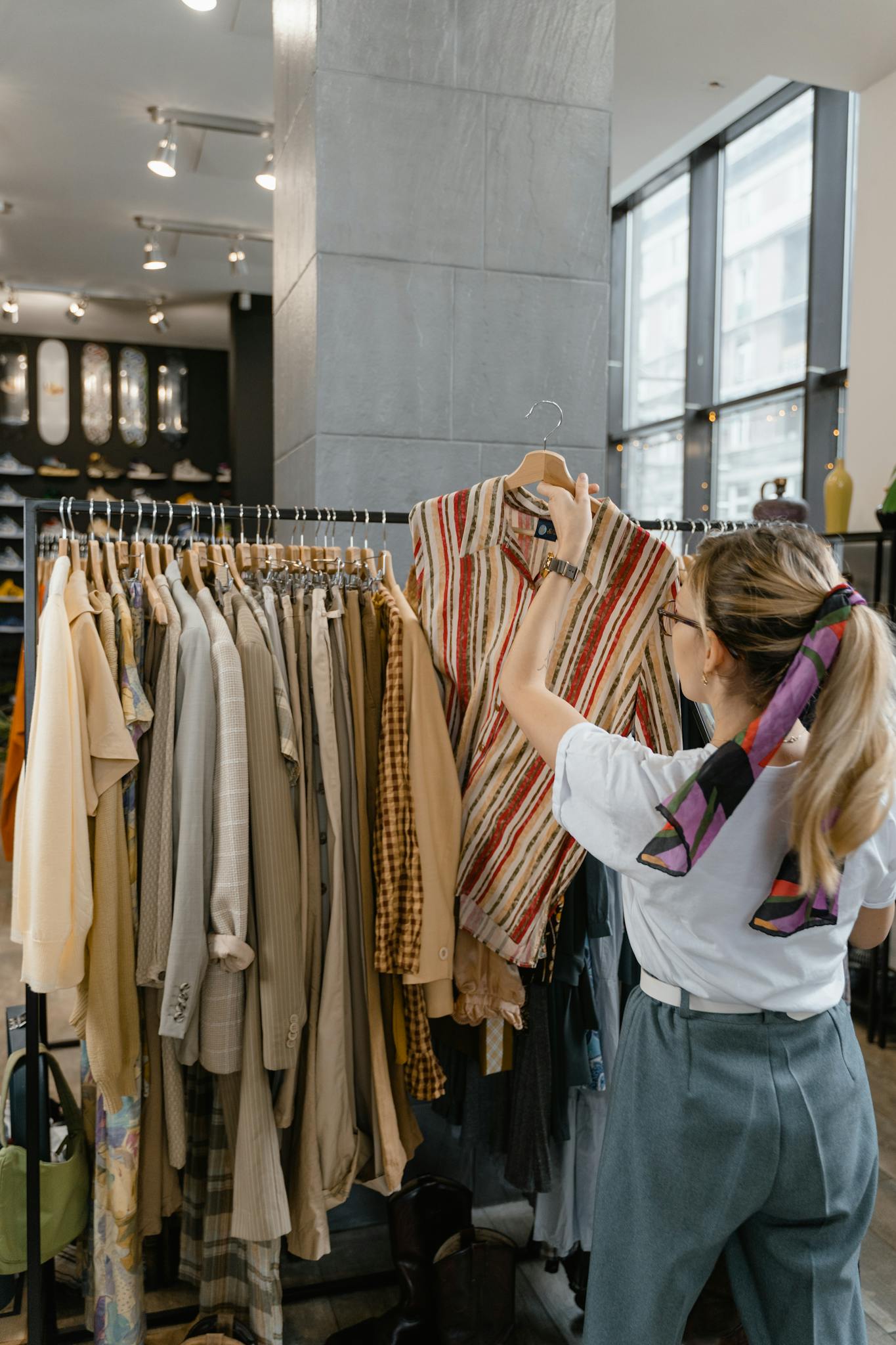 A Woman Browses Clothes On A Rack